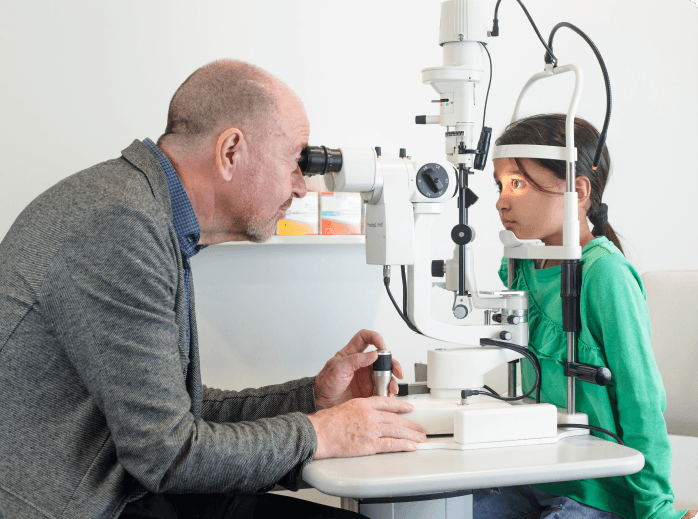 Young girl with blurry vision having eyes checked by children's ophthalmologist at My-iClinic in London.